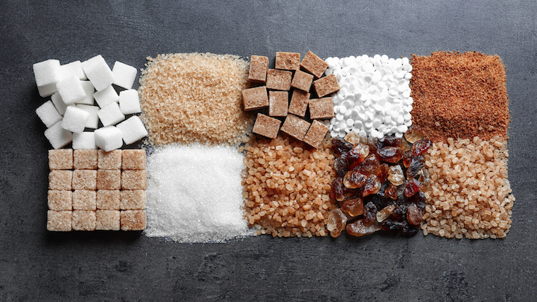 Different types of sugar on a flat surface or tabletop.