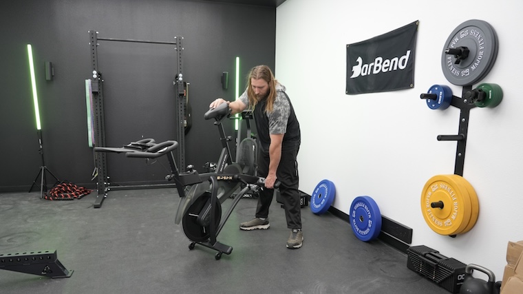 Our tester getting the Bells of Steel Blitz Air Bike 2.0 into position for a workout