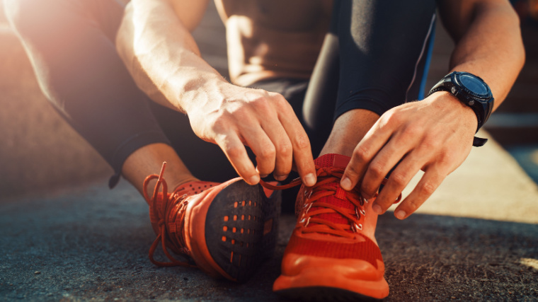 An athlete fixing their shoelace.