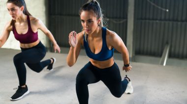 Two people doing the jumping lunge.