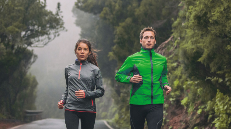 Two fit people running outdoors on cold weather.