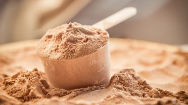A scoop of protein powder on a bed of protein powder.