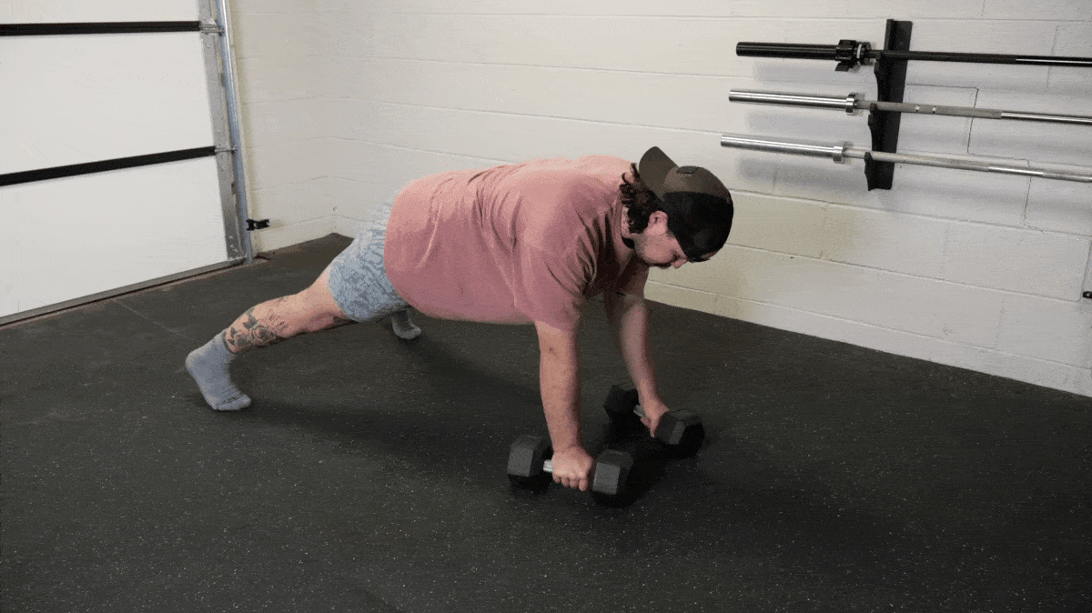 A person performing the renegade row with dumbbells.