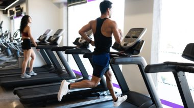 An athlete running on a treadmill in the gym.