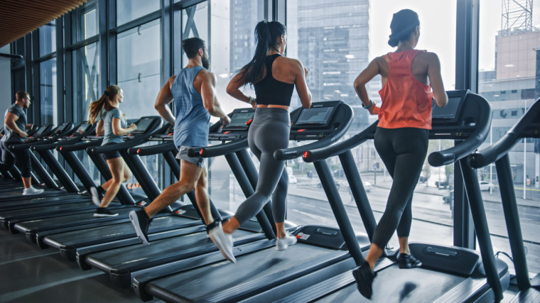 A group of athletic people running on a treadmills.