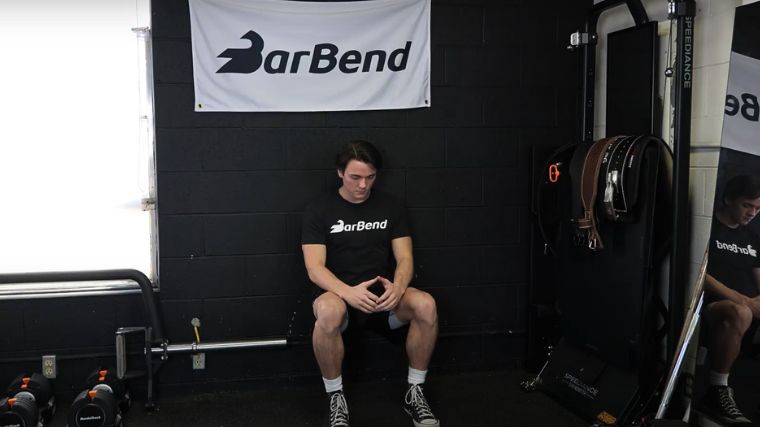 A person performing the wall sit exercise.
