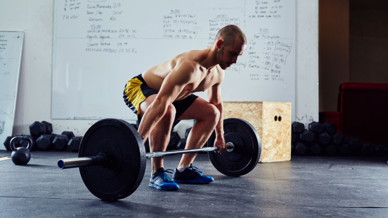 A person preparing to lift a barbell.