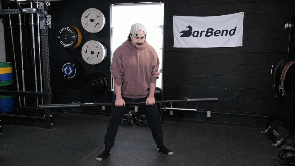 A person performing the sumo deadlift high pull exercise.