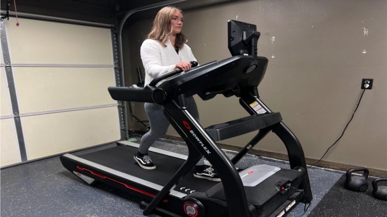 Front view of a woman walking on a BowFlex Treadmill 10.