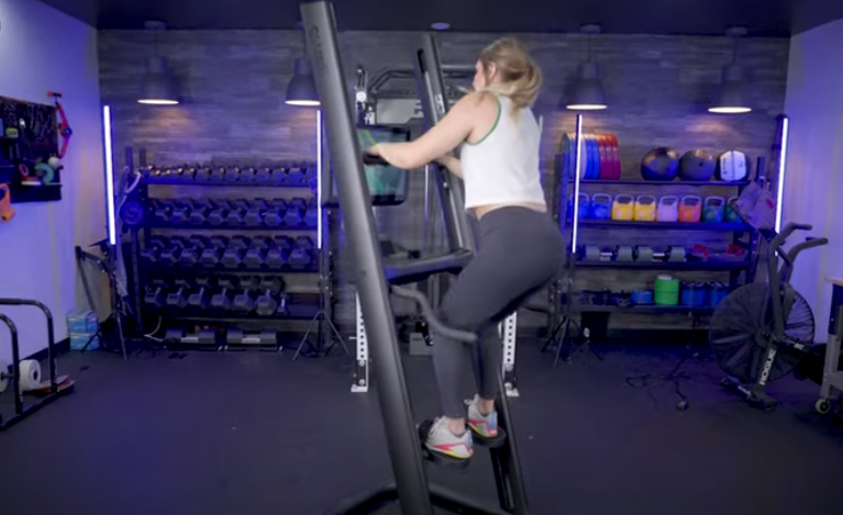 A woman working out with the CLMBR Connected 02 equipment.