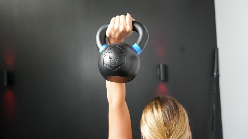 A BarBend tester holding up the 26-pound Iron Bull Kettlebell.