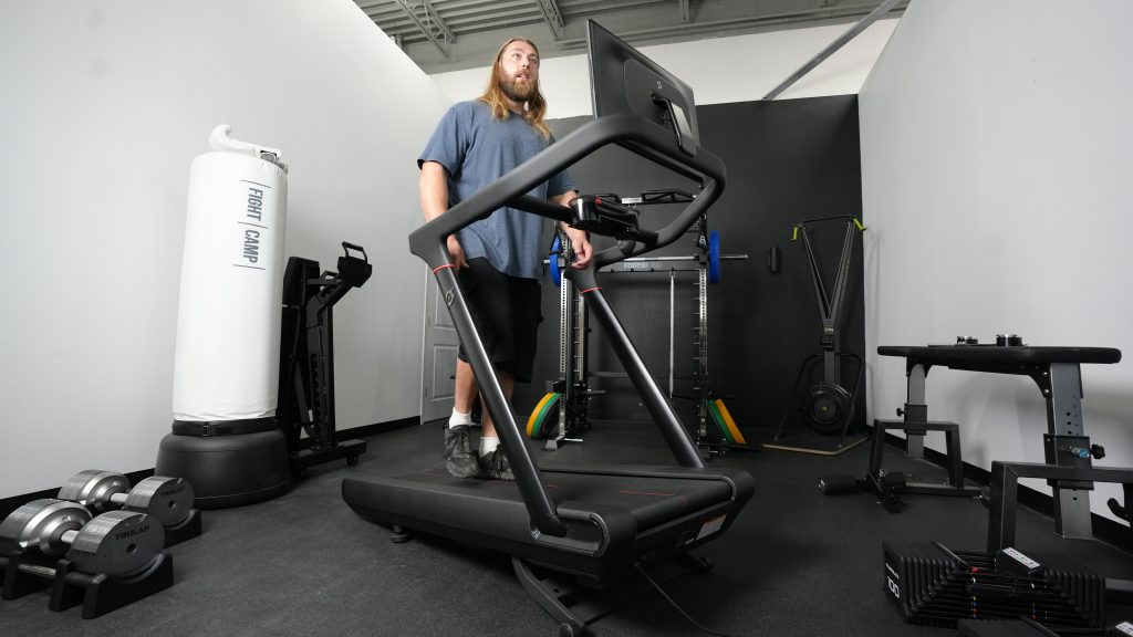 A person walks at an incline with the Peloton Tread treadmill