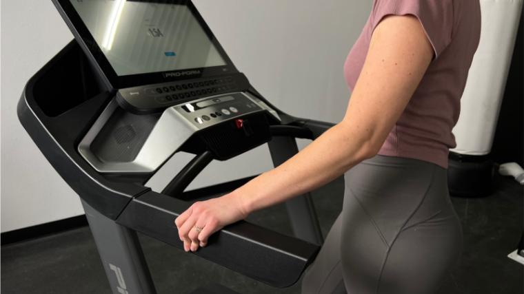 A person is shown holding the handlebars while walking on a ProForm 9000 Treadmill.