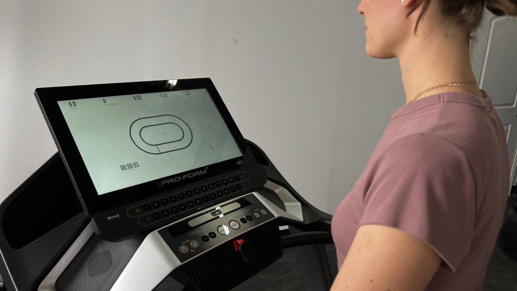 A BarBend product tester is shown using the HD touchscreen on the ProForm Pro 9000