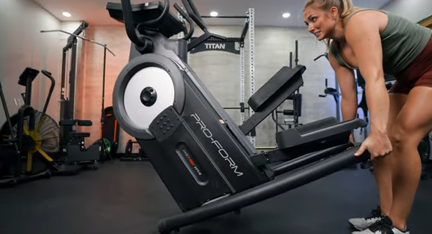 A person tipping the ProForm Pro HIIT H14 stair-stepping machine.