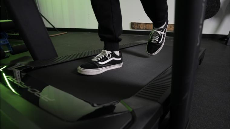 A pair of feet walking on the ProForm TLX treadmill. 