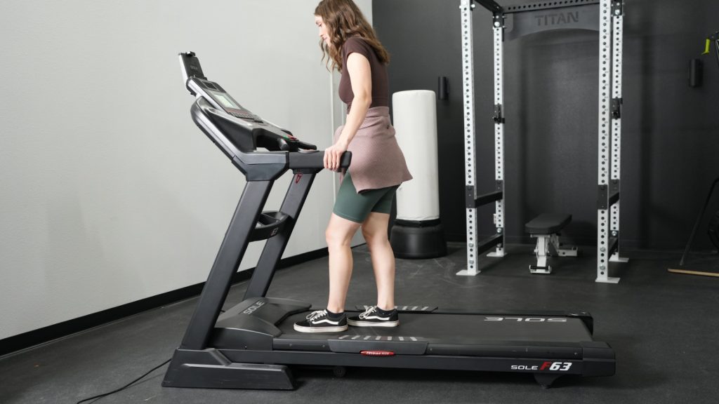 A woman standing on a Sole F63 treadmill