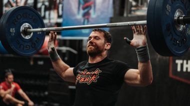A trainer dropping a barbell.