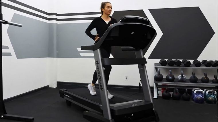 BarBend's Lauren Keary doing a HIIT workout on a treadmill.