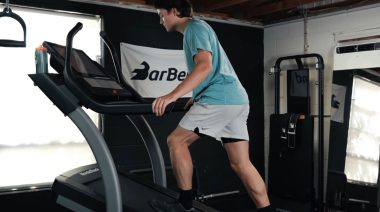 A person working out in an inclined treadmill.