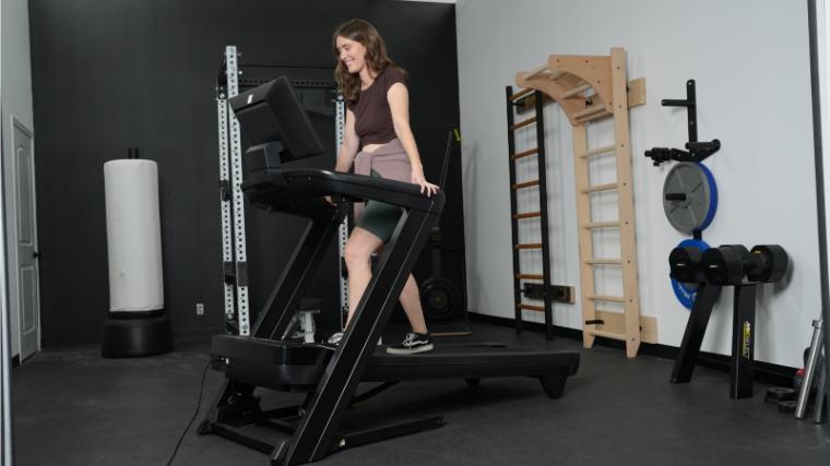 A woman walks at an incline on the NordicTrack 1250 Treadmill.