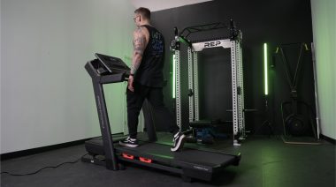 A BarBend tester walking on a ProForm Carbon TLX treadmill.