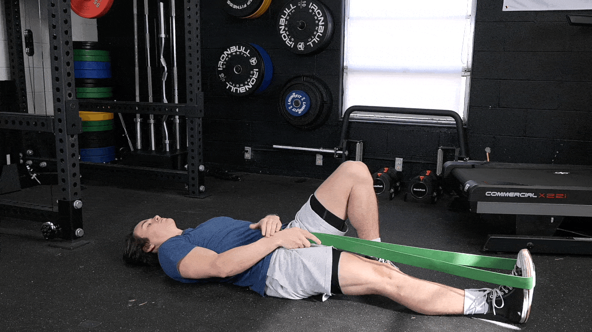 Jake performing the assisted supine hamstring stretch with a resistance band.