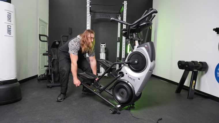 A person moves the Bowflex Max Trainer M6 into position for a workout.