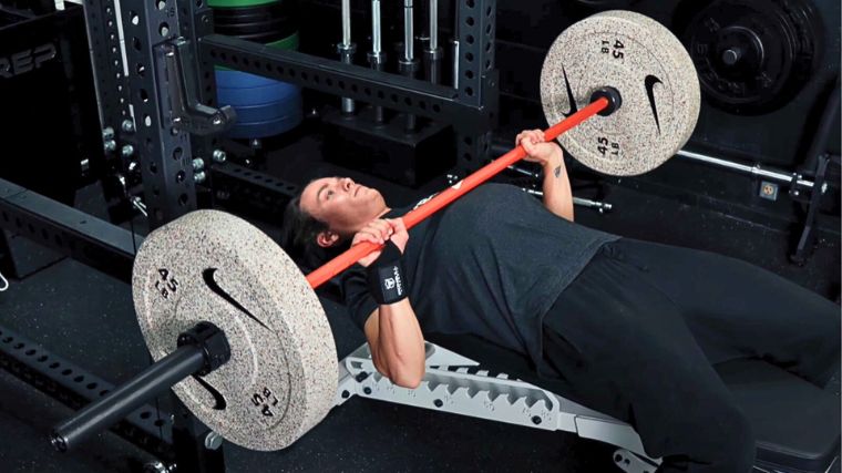 A person doing the bench press, following one of the bench press programs.