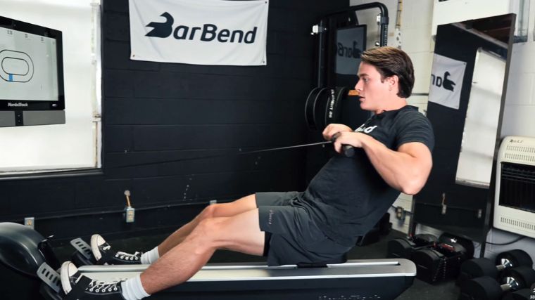 A person working out on a rowing machine.