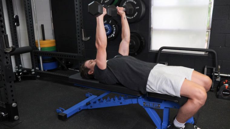 A person doing the dumbbell bench press.