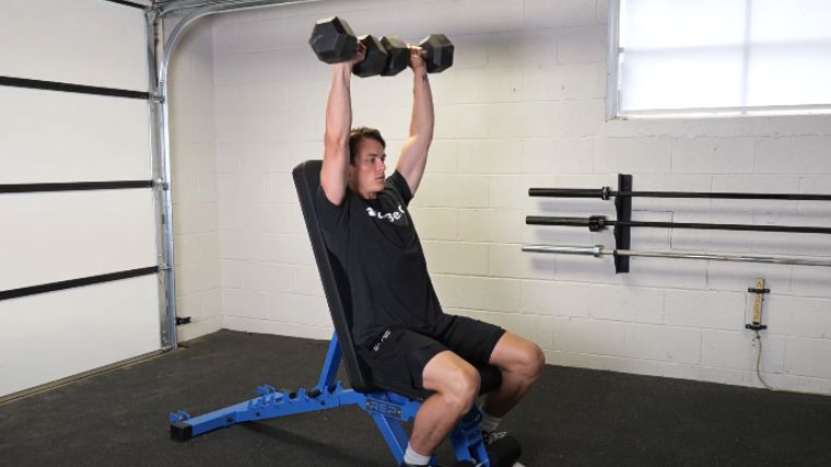 A person performing the dumbbell shoulder press.