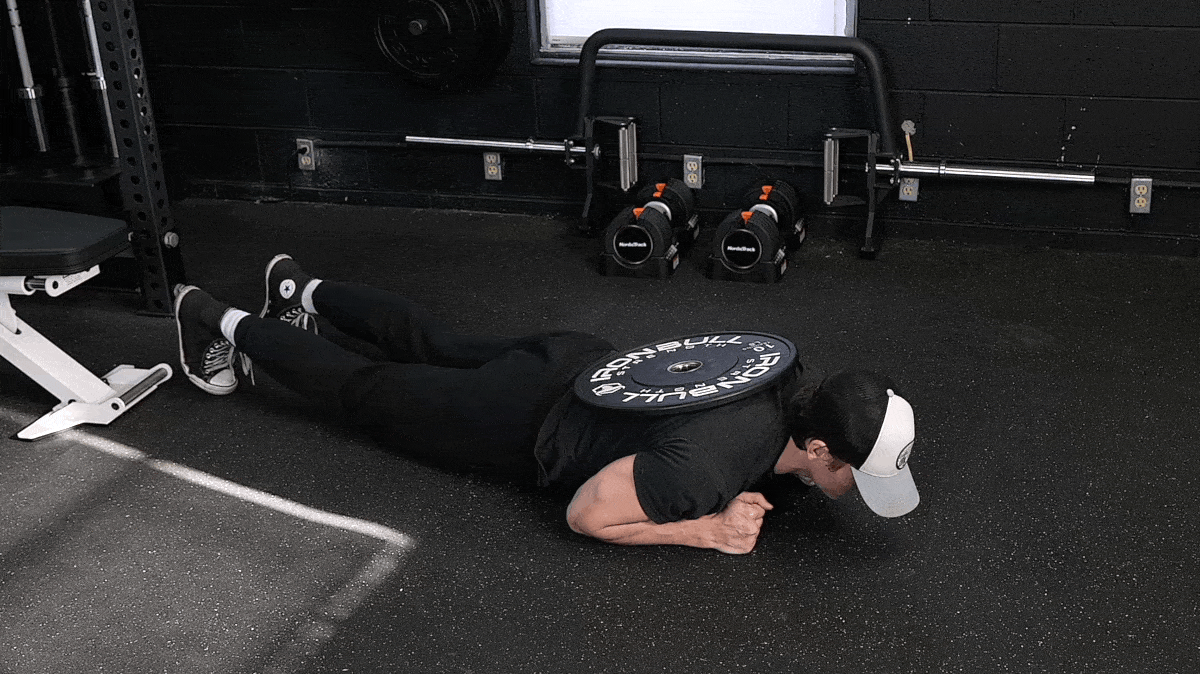 A person performing the weighted plank.