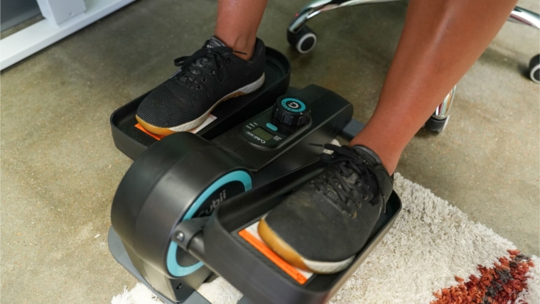 Close look at our tester pedaling on the Cubii Move under-desk elliptical.