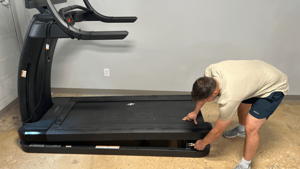 A person adjusting the treadmill belt of the NordicTrack X32i.