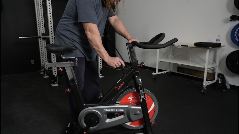 Our tester adjusting the resistance on the SF-B1002 exercise bike from Sunny Health and Fitness