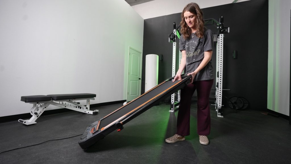 Our tester moving the Urevo 2-in-1 Under-Desk Treadmill.