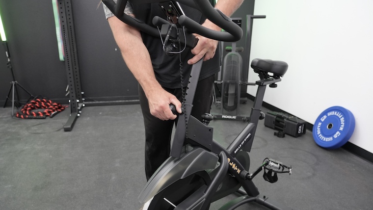 Our tester adjusts the Bells of Steel Indoor Cycling Bike.