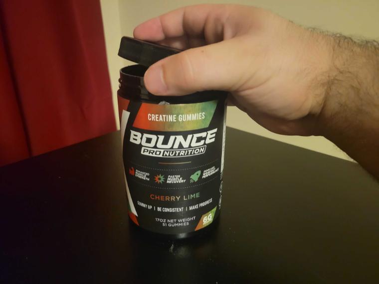 A person opening a container of Bounce Creatine Gummies