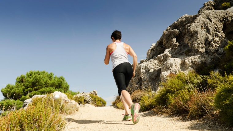 A person running up a hill, doing a hill running workout.