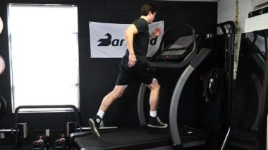 A person running on a treadmill in the BarBend gym.
