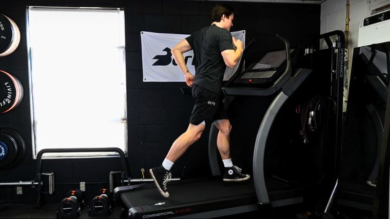 A person running on a treadmill in the BarBend gym.