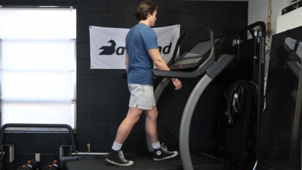 a person walking on a treadmill in a garage gym