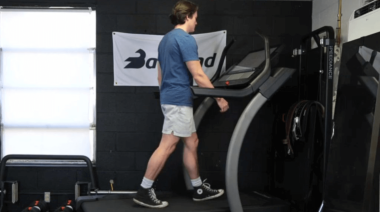 a person walking on a treadmill in a garage gym