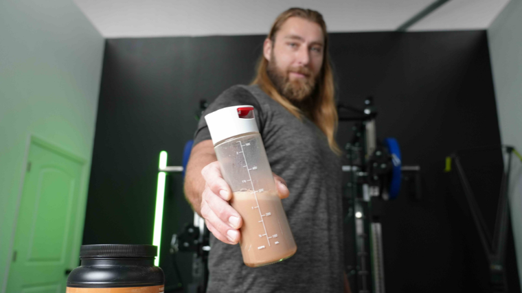 Our tester holding a shaker bottle with his prepared supplement drink.