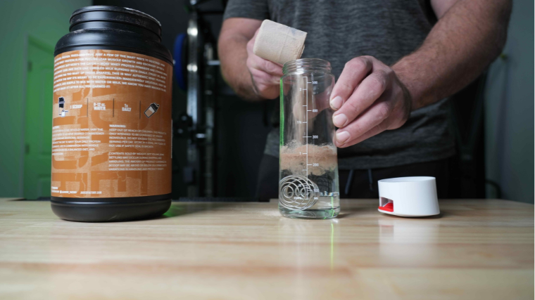 Our tester preparing Jacked Factory Authentic protein powder drink in a shaker bottle.