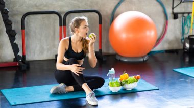A person eating healthy foods in the gym.