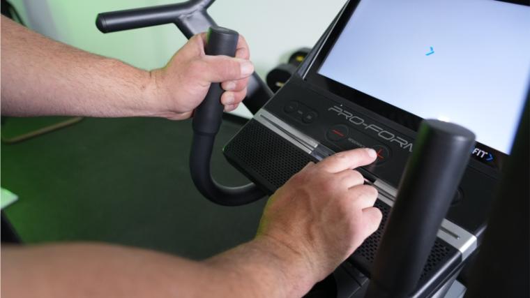 Our tester adjusting the controls on the ProForm Pro HIIT H14 Elliptical.