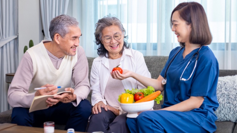 A nutritionist offering two people foods high in probiotics.