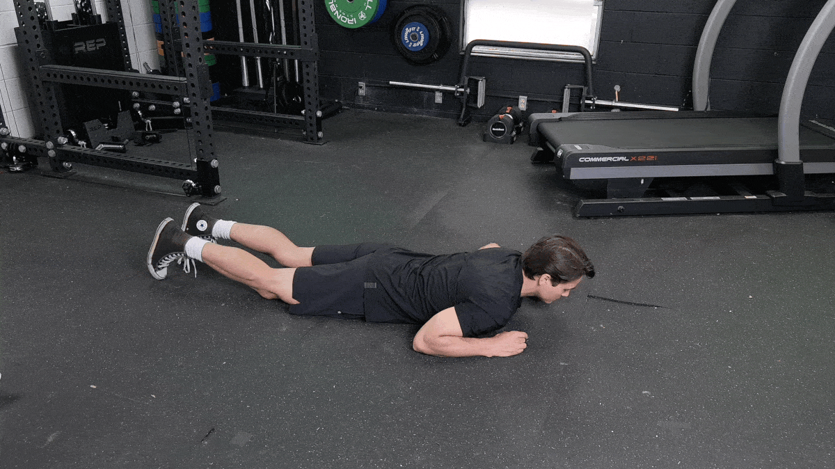 BarBend's Jake Herod performing the prone quad stretch.